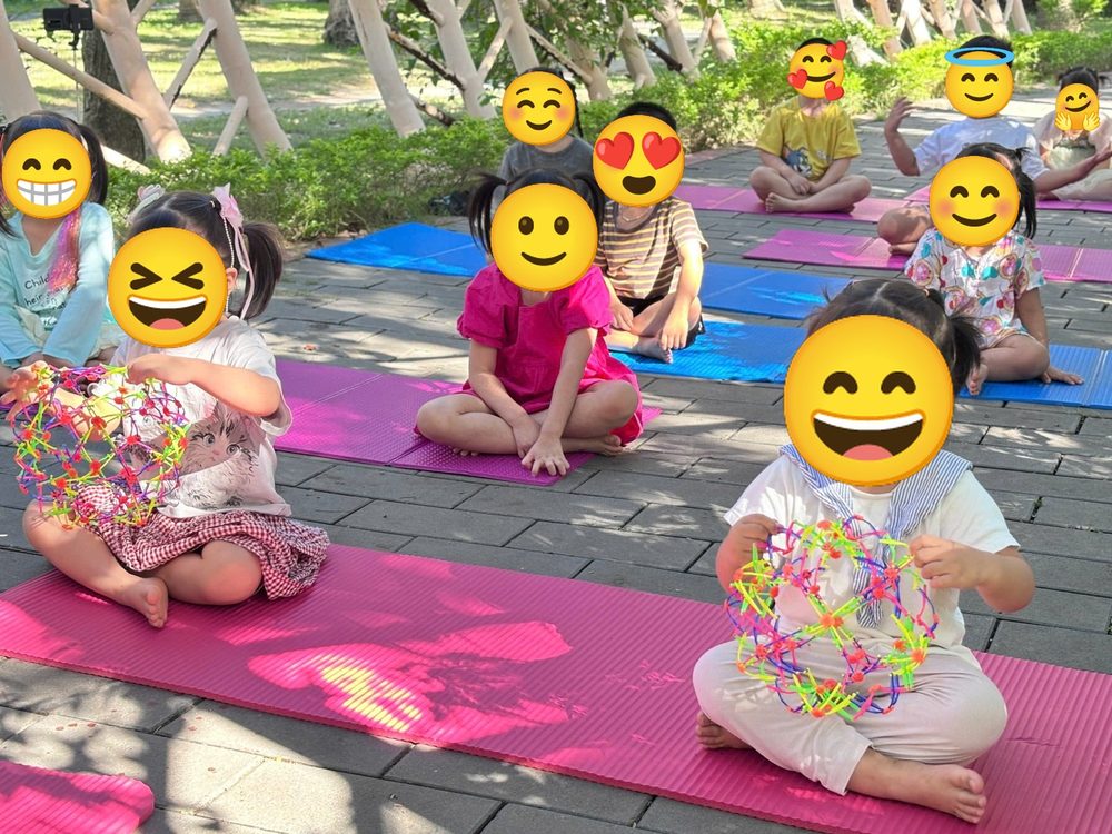 Các bé lớp Mầm Non ngồi trên thảm tập thở với bóng thở